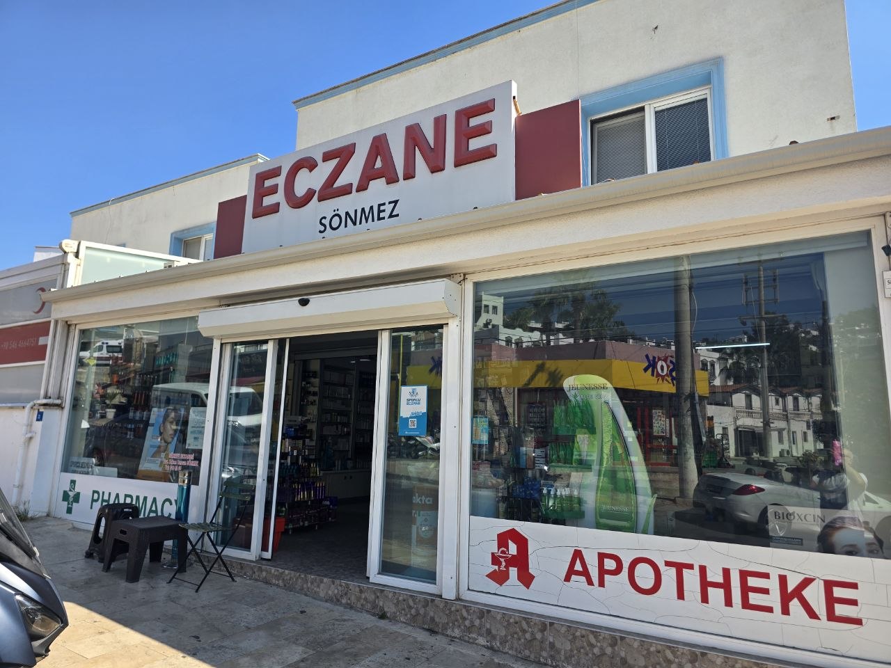 Sönmez Eczanesi'nin Gümbet'teki girişi: ECZANE SÖNMEZ tabelası ve APOTHEKE yazılı vitrin